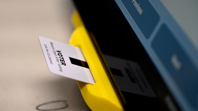 In this Nov. 5, 2019 file photo, an electronic card with ballot information is seen inserted in a voting machine in Dallas, GA.