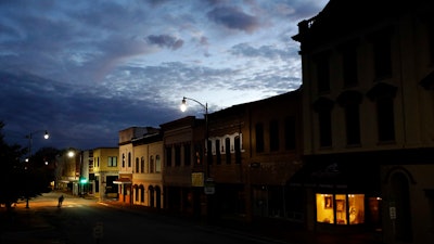 In this Oct. 28, 2017 file photo, the storefront window of a portrait studio is lit up along a downtown street at dusk in Lumberton, N.C. With a little over one month to go in 2019, small business owners should think about purchases or investments that make good business sense and will give them a break on their taxes.