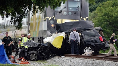In this Aug 25, 2019 file photo, Broward Sheriff's Deputies and Pompano Beach Fire Rescue work the scene of a fatal accident on North Dixie Highway in Pompano Beach, Fla. The Florida higher-speed passenger train service tied to Richard Branson’s Virgin Group has the worst per-mile death rate in the U.S. The first death involving a Brightline train happened in July 2017 during test runs. An Associated Press analysis of Federal Railroad Administration data shows that since then, 40 more have been killed. That amounts to a rate of more than one a month and about one for every 29,000 miles (47,000 kilometers) the trains have traveled since the first death.