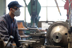 An employee wears a facemask as he works at a blower and fan manufacturing plant.