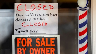 In this April 2, 2020 file photo, 'For Sale By Owner' and 'Closed Due to Virus' signs are displayed in the window of a store in Grosse Pointe Woods, Mich. The second round of loan applications for the government's small business relief program has been slowed by computer issues at the Small Business Administration. Lenders complained Monday, April 27, that they couldn't get their applications into the SBA system known as ETran that processes and approves loans.