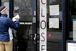 A man writes information in front of Illinois Department of Employment Security in Chicago, April 30, 2020.