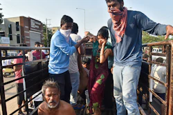 People affected by a chemical gas leak are carried out of a truck to an ambulance in Vishakhapatnam, India.