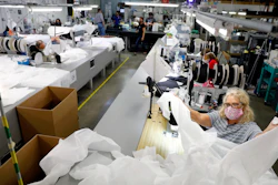 Angie Moorefield unfolds material to begin sewing a disposable gown at Burlington Medical in Newport News Wednesday, May 6. The manufacturing business recently shifted from producing radiation protection gear for medical facilities to in-demand personal protective equipment such as masks, gowns and plastic face shields.