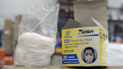 An opened box of protective masks sits on a pallet at Direct Relief's distribution center in Santa Barbara, Calif.