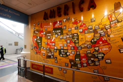 A lone security officer walks past a map of America in the main terminal of Denver International Airport.