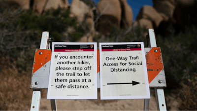 Signs advise visitors to social distance at Joshua Tree National Park in California.