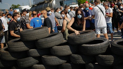 A woman makes a barricade off tyres during a protest by Nissan workers in Barcelona, Spain.