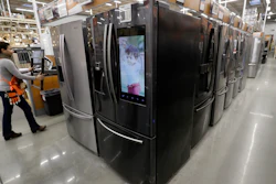 In this Jan. 27, 2020 file photo, a worker pushes a cart past refrigerators at a Home Depot store location in Boston.