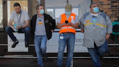 Protesting Renault workers stand outside their plant.