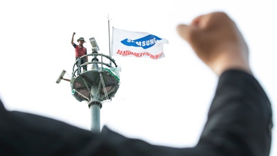 A former Samsung employee Kim Yong-hee is seen atop an 82-foot traffic camera tower in Seoul, South Korea.