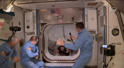 This photo provided by NASA shows the crew of SpaceX entering the International Space Station, Sunday, May 31, 2020. The Dragon capsule arrived Sunday morning, hours after a historic liftoff from Florida. It's the first time that a privately built and owned spacecraft has delivered a crew to the orbiting lab.