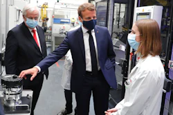 French President Emmanuel Macron, center, wearing a protective face mask, listens to explanations by an employee as CEO of France-based multinational automotive supplier Valeo Jacques Aschenbroicha looks on, in Etaples, , northern France, Tuesday May 26, 2020. Emmanuel Macron announced a 8 billion euro ($8.8 billion) plan to save the country's car industry from huge losses wrought by virus lockdowns, including a big boost for electric vehicles. The plan includes government subsidies for car buyers and longer-term investment in innovative technology, especially in battery-powered cars.