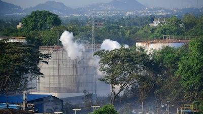 Smoke rises from LG Polymers plant, the site of a chemical gas leakage, in Vishakhapatnam, India, Thursday, May 7, 2020. Synthetic chemical styrene leaked from the industrial plant in southern India early Thursday, leaving people struggling to breathe and collapsing in the streets.