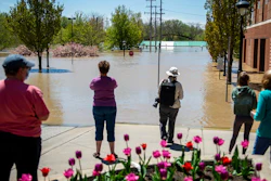 People check out the flooding near the H Hotel in downtown Midland, Mich., on Wednesday, May 20, 2020. After the Edenville Dam failed and the Tittabawassee River flooded surrounding areas, many residents were urged to leave their homes.