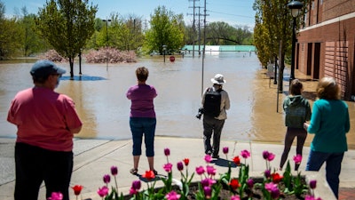 People check out the flooding near the H Hotel in downtown Midland, Mich., on Wednesday, May 20, 2020. After the Edenville Dam failed and the Tittabawassee River flooded surrounding areas, many residents were urged to leave their homes.