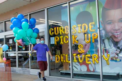 A Party City employee delivers balloons to a customer curbside, Wednesday, May 27, 2020, in Oceanside, N.Y. Long Island has become the latest region of New York to begin easing restrictions put in place to curb the spread of the coronavirus as it enters the first phase of the state's four-step reopening process.