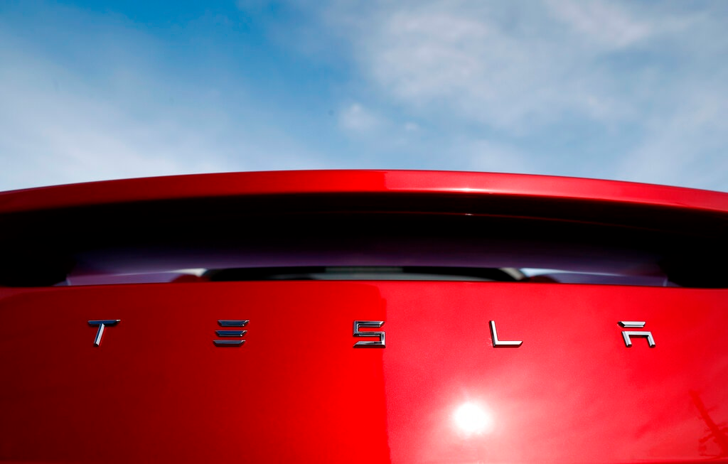 In this April 15, 2018 file photo, the sun shines off the rear deck of a roadster on a Tesla dealer's lot in the south Denver suburb of Littleton, Colo. Tesla has picked Austin, Texas, and Tulsa, Oklahoma, as finalists for its new U.S. assembly plant, a person briefed on the matter said Friday, May 15, 2020.