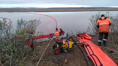 Rescuers work to prevent the spread of an oil spill outside Norilsk, Russia, June 2, 2020.