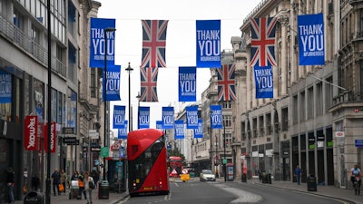Union flags and support messages are seen in the shopping street, Oxford Street, ahead of the reopening of the non-essential businesses on Monday, June 15, as some of the coronavirus lockdown measures are eased, in London, Friday, June 12, 2020. The British economy shrank by a colossal 20.4% in April, the first full month that the country was in its coronavirus lockdown, official figures showed Friday.