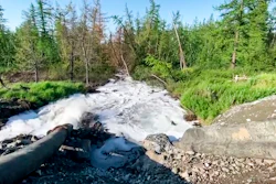 Water from a Norilsk Nickel enrichment plant gushing out of a pipe and into a river.