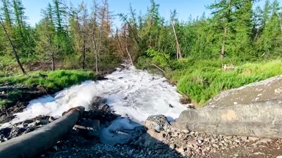 Water from a Norilsk Nickel enrichment plant gushing out of a pipe and into a river.