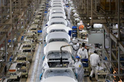 Employees work on a car assembly line.