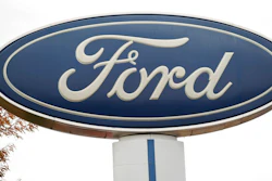 In this Oct. 20, 2019, file photo, the company logo stands over a long row of unsold vehicles at a Ford dealership in Littleton, Colo. Ford is recalling about 2.5 million vehicles in the U.S., Canada and elsewhere because of a nagging door latch problem and a brake fluid leak. The door latch recall covers more than 2.1 million cars, SUVs and vans in the U.S. The latches can fail and cause the doors to open while the vehicles are moving. It's the third recall for the same problem.
