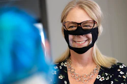 In this June 3, 2020, photo, Chris LaZich, of Fleet Science Center, wears a mask with a window as she talks with Delpha Hanson in San Diego. Face coverings to curb the spread of the coronavirus are making it hard for people who read lips to communicate. That has spurred a slew of startups making masks with plastic windows to show one's mouth. The companies are getting inundated with orders from family and friends of deaf people, people helping English learners see the pronunciation of words, and even hospitals that want their patients to be able to see smiles.