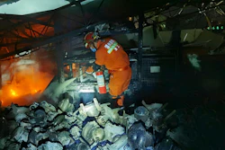 A firefighter puts out fire in the aftermath of a tanker truck explosion that damaged buildings near a highway in Wenling in eastern China's Zhejiang province Saturday, June 13, 2020. More than a dozen were killed and others injured after the tanker truck veered off the Shenyang-Haikou Expressway after the explosion.