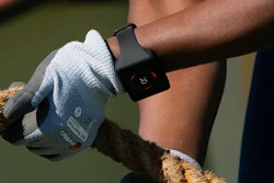 A tugboat deckhand demonstrates a digital bracelet that flashes red when a coworker is too close to him.