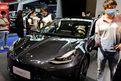 Visitors look at a Tesla Model 3 vehicle on display at an auto show in southwestern China's Chongqing Municipality, June 13, 2020.