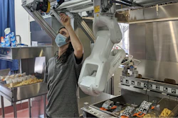 A technician makes an adjustment to a robot at Miso Robotics' White Castle test kitchen.