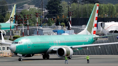 Workers stand near a Boeing 737 Max 8 jetliner being built for American Airlines.