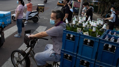 A delivery man transports beer on the streets of Beijing.