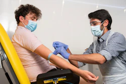 In this handout photo, a doctor takes blood samples for use in a coronavirus vaccine trial in Oxford, England, June 25, 2020.