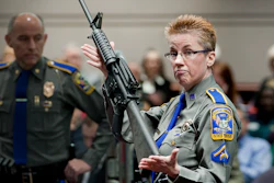 Firearms training unit Detective Barbara J. Mattson, of the Connecticut State Police, holds up a Bushmaster AR-15 rifle.