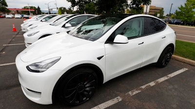 In this Sunday, June 28, 2020 file photo, 2020 Model Y electric sports-utility vehicles sit in the parking lot of a Tesla store in Littleton, Colo. Tesla overcame a seven-week pandemic-related shutdown at its U.S. assembly plant to post a $104 million net profit for the second quarter.