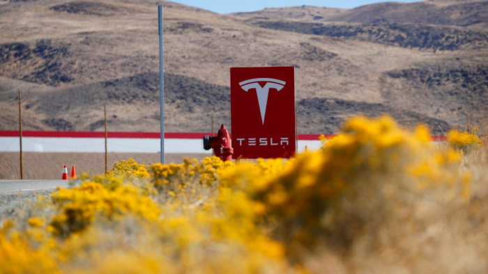 In this Oct. 13, 2018 file photo, a sign marks the entrance to the Tesla Gigafactory in Sparks, Nev. Tesla CEO Elon Musk solved a mystery involving a 27-year-old Russian who prosecutors say flew to the United States to offer a major-company insider $1 million to assist in a ransomware extortion attack on the firm. According to the billionaire, the scheme took aim at the electric car company’s 1.9 million-square-foot factory in Sparks, Nevada, which makes batteries for Tesla vehicles and energy storage units.