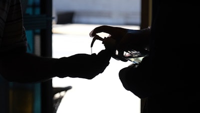 Hand sanitizer is squirted into a worshiper's hands as they enter for a Sunday Mass at a church in Paterson, N.J., June 14, 2020.