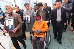 Kim Sung-joo, bottom center, a victim of Japan's forced labor, arrives at the Supreme Court's in Seoul, South Korea.