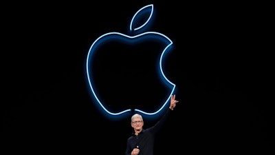 In this June 3, 2019, file photo, Apple CEO Tim Cook waves after speaking at the Apple Worldwide Developers Conference in San Jose, Calif. Cook has forged his own distinctive legacy. He will mark his ninth anniversary as Apple’s CEO Monday, Aug. 24, 2020 -- the same day the company will split its stock for the second time during his reign.