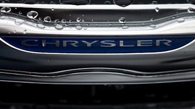 In this Dec. 2, 2014 file photo, a Chrysler minivan sits under rain at a car lot in San Diego. The U.S. government’s road safety agency, on Monday, Aug. 10, 2020, is investigating complaints of fires in a power and charging port in some Chrysler Town and Country minivans. The National Highway Traffic Safety Administration says it has three reports of fires and one injury in minivans from the 2014 model year.