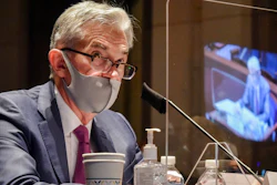 In this June 30, 2020, file photo Federal Reserve Board Chairman Jerome Powell, reflected in the sneeze guard set up between himself and members of the House Committee on Financial Services, speaks during a hearing on oversight of the Treasury Department and Federal Reserve pandemic response on Capitol Hill in Washington. With the economy still in the pandemic’s grip, the Federal Reserve is facing a decision on whether to stretch an emergency lending program in a way that could bring more risk for the government and taxpayers. Lawmakers are pressing the central bank to deliver more aid to struggling small and mid-sized businesses.