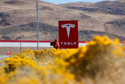 In this Oct. 13, 2018 file photo, a sign marks the entrance to the Tesla Gigafactory in Sparks, Nev. Tesla CEO Elon Musk solved a mystery involving a 27-year-old Russian who prosecutors say flew to the United States to offer a major-company insider $1 million to assist in a ransomware extortion attack on the firm. According to the billionaire, the scheme took aim at the electric car company’s 1.9 million-square-foot factory in Sparks, Nevada, which makes batteries for Tesla vehicles and energy storage units.