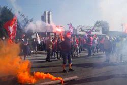 Bridgestone employees fire flares outside the tire factory of Bethune, northern France, Thursday, Sept.17, 2020. Workers protest over the Japan-based company's decision to close the plant and lay off all its nearly 900 workers. Bridgestone argues the factory is no longer competitive globally, but unions and French politicians accused the company of using the virus-driven economic crisis as a pretext for the closure and not investing in modernizing the plant instead.
