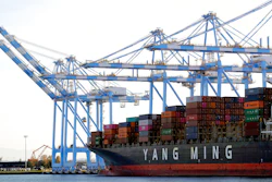 Cargo cranes are used to take containers off of a Yang Ming Marine Transport Corporation boat at the Port of Tacoma in Tacoma, Wash.