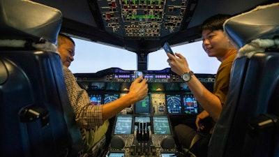 Customers take selfie photos in an Airbus A380 flight simulator.