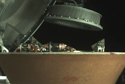 In this undated image provided by NASA, a sample container hovers over a capsule on the Osiris-Rex spacecraft near the asteroid Bennu.