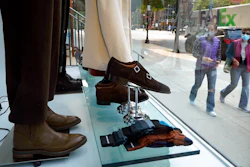 In this Tuesday, Sept. 15, 2020, file photo, passers-by examine a storefront window in Boston's fashionable Newbury Street shopping district. U.S. consumer confidence dipped slightly in October as a new wave of coronavirus cases began across the country. The Conference Board reported Tuesday, Oct. 27, 2020, that its consumer confidence index fell to a reading of 100.9, from 101.8 in September.